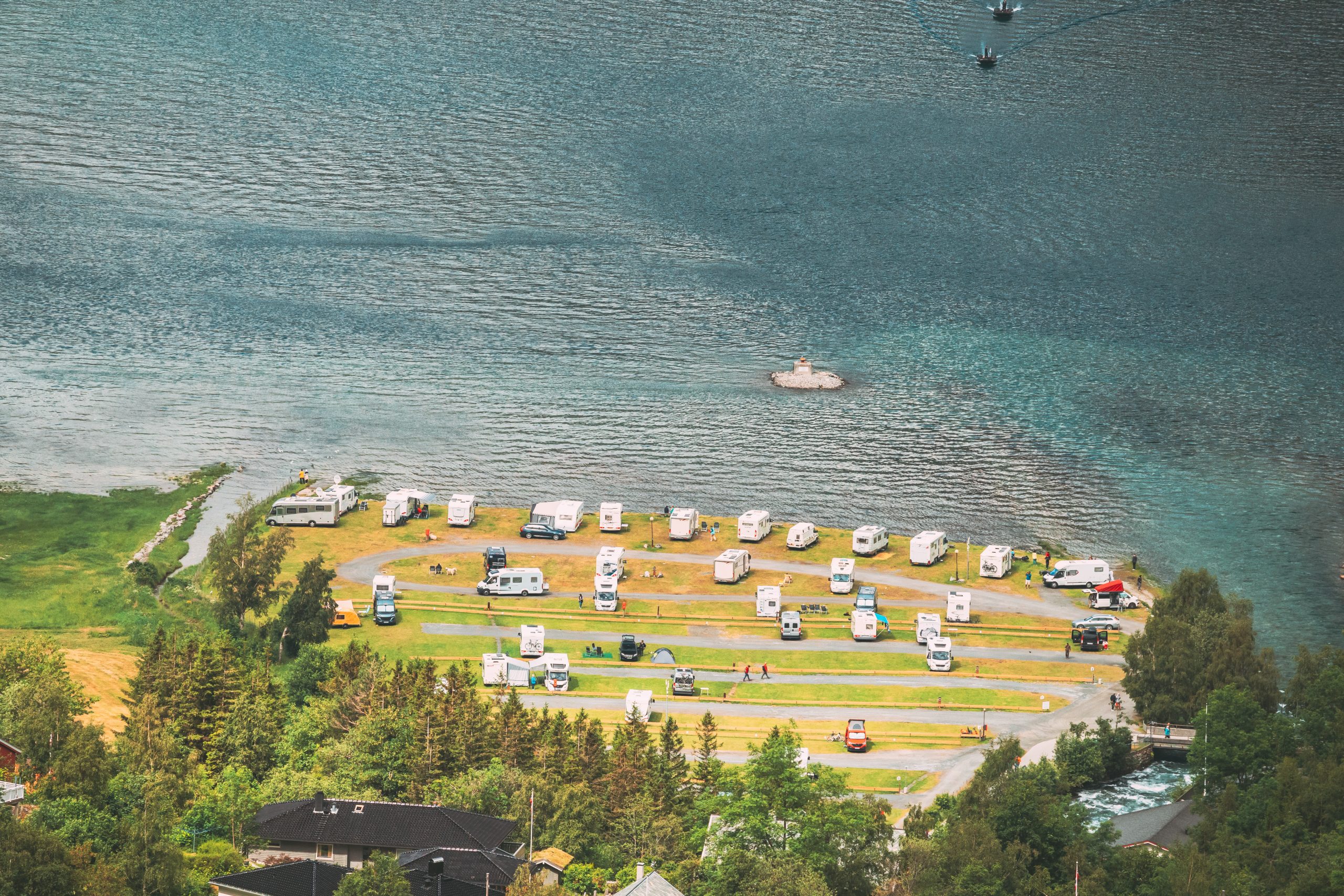 Geirangerfjord, Norway. Caravan Motorhome Cars Parking Near Harbor. Aerial View In Summer Day. Geirangerfjord, Norway. Caravan Motorhome Cars Parking Near Harbor. Aerial View In Summer Day.